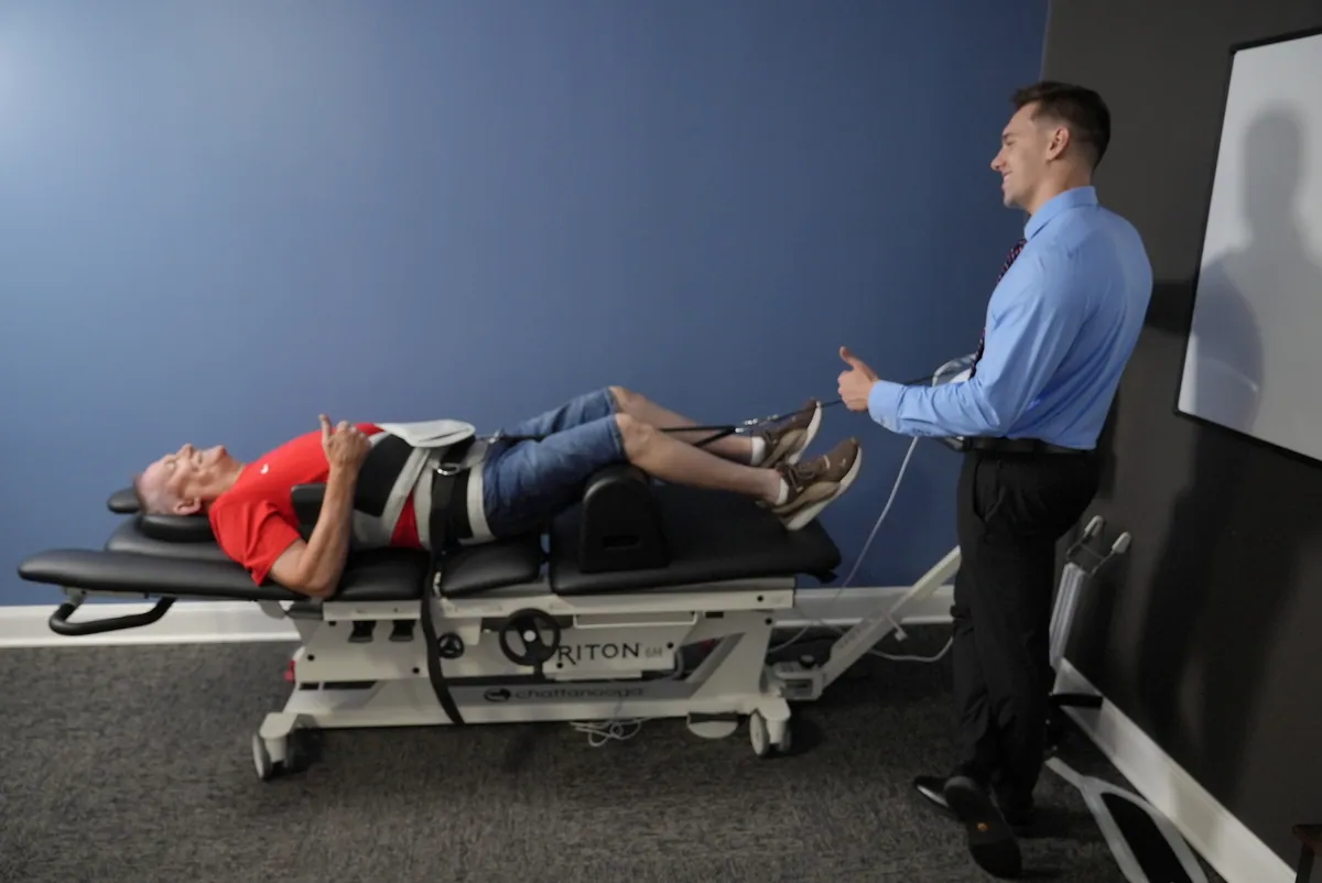 Patient on a spinal decompression table with Dr. C.J. Levand