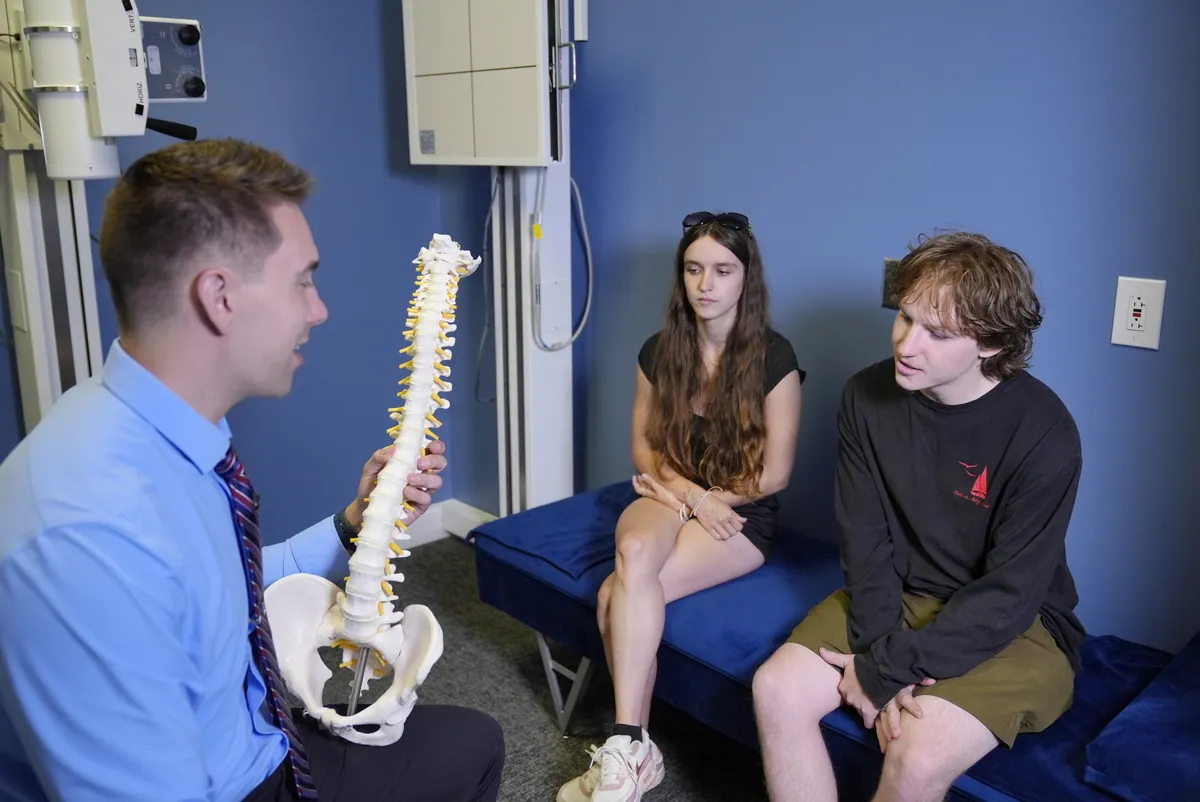 Dr. C.J. Levand explaining the spine to a mother and teen