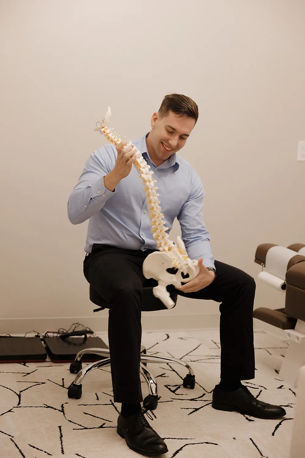 Chiropractor explaining spinal decompression therapy using a spine model