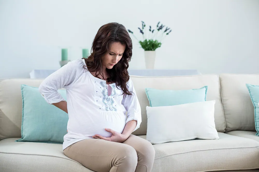 Pregnant woman managing pregnancy discomfort with prenatal chiropractic care