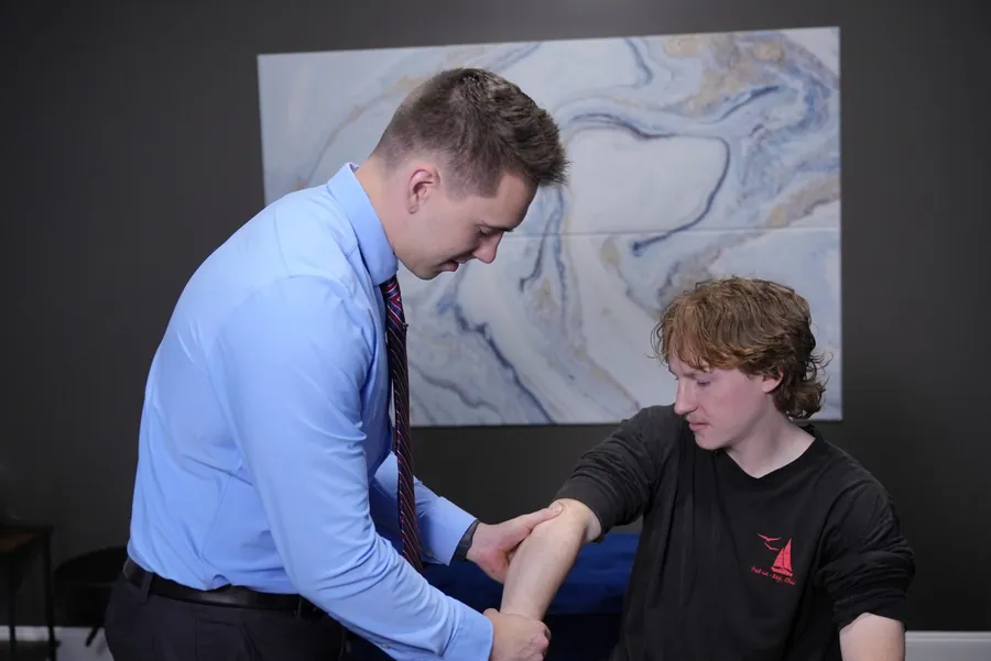 Dr. C.J. Levand examining a teen’s elbow