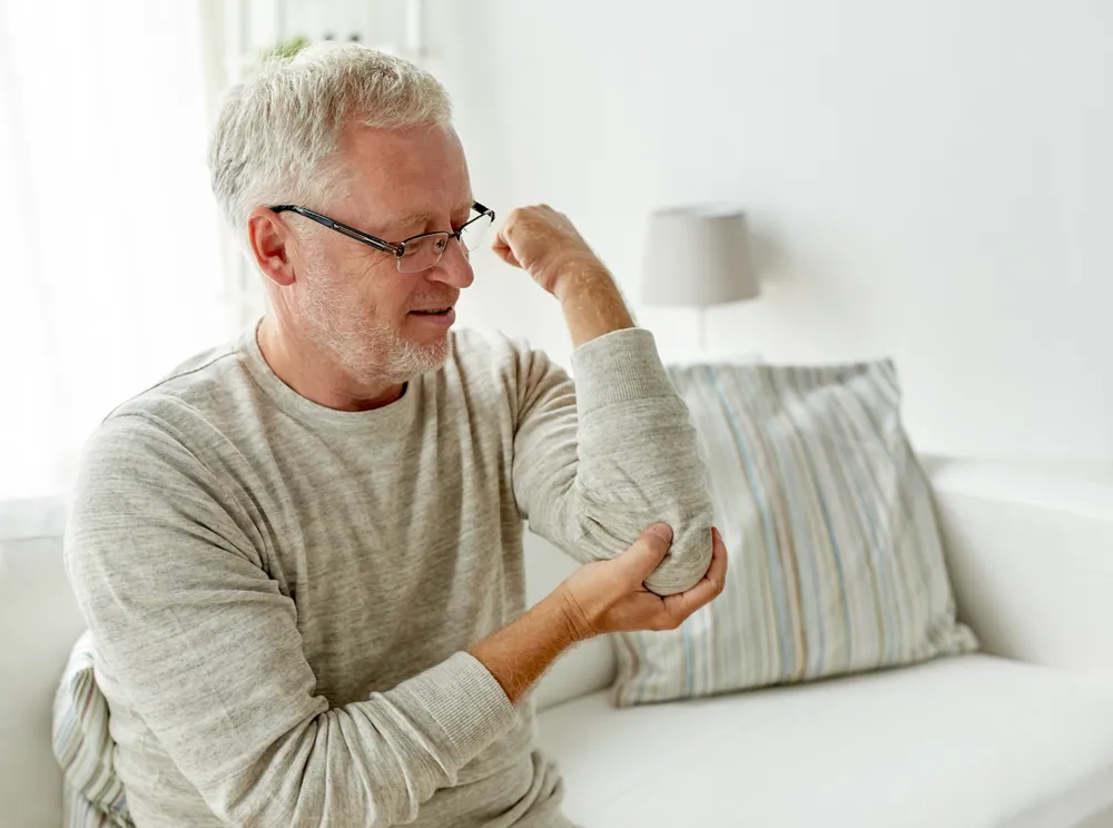 Older adult with elbow stiffness benefiting from chiropractic elbow pain treatment