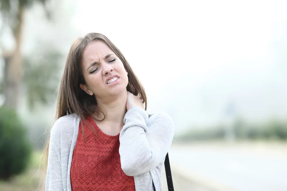 Woman experiencing chronic neck pain associated with fibromyalgia